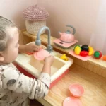 zaisline-virtuvine-kriaukle-su-tekanciu-vandeniu-ir-priedais-rozine